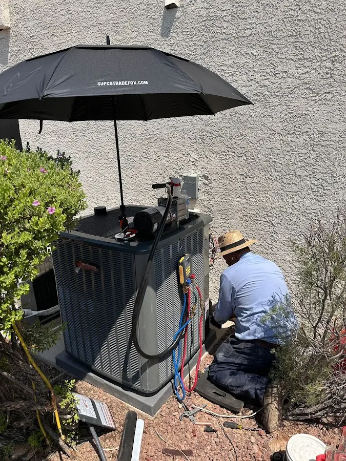 HVAC technician performing outdoor AC maintenance in Siloam Springs