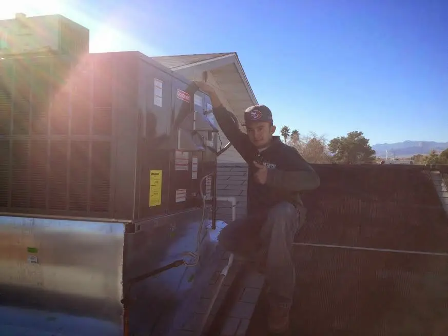 HVAC technician performing AC Tune-Up on a rooftop unit in Siloam Springs